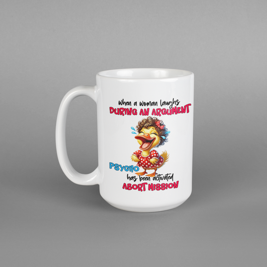 A white coffee mug with a cartoon duck on it with the text that says when a woman laughs during an argument psych has been activated abort mission