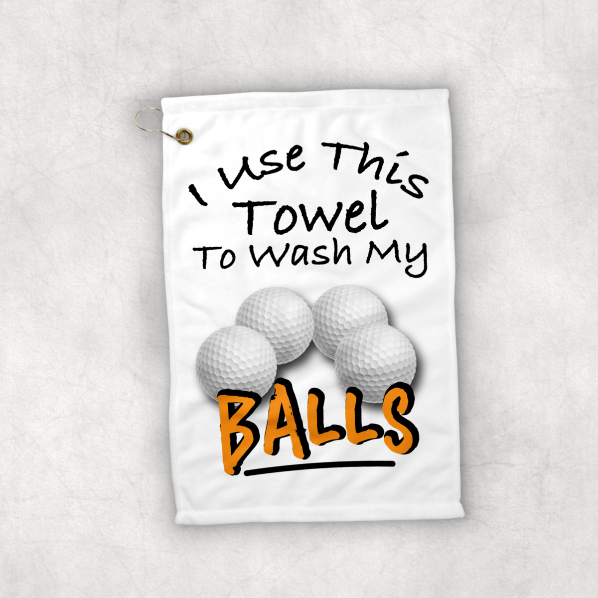 A 12x18 inch white golf towel that says in black writing Use this towel to wash my balls. With a picture of four golf balls