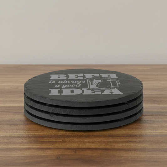 A round black coaster with a textured finish featuring the phrase 'BEER is always a good IDEA' in gray lettering alongside an illustration of a frothy beer mug, shown on a plain white background.