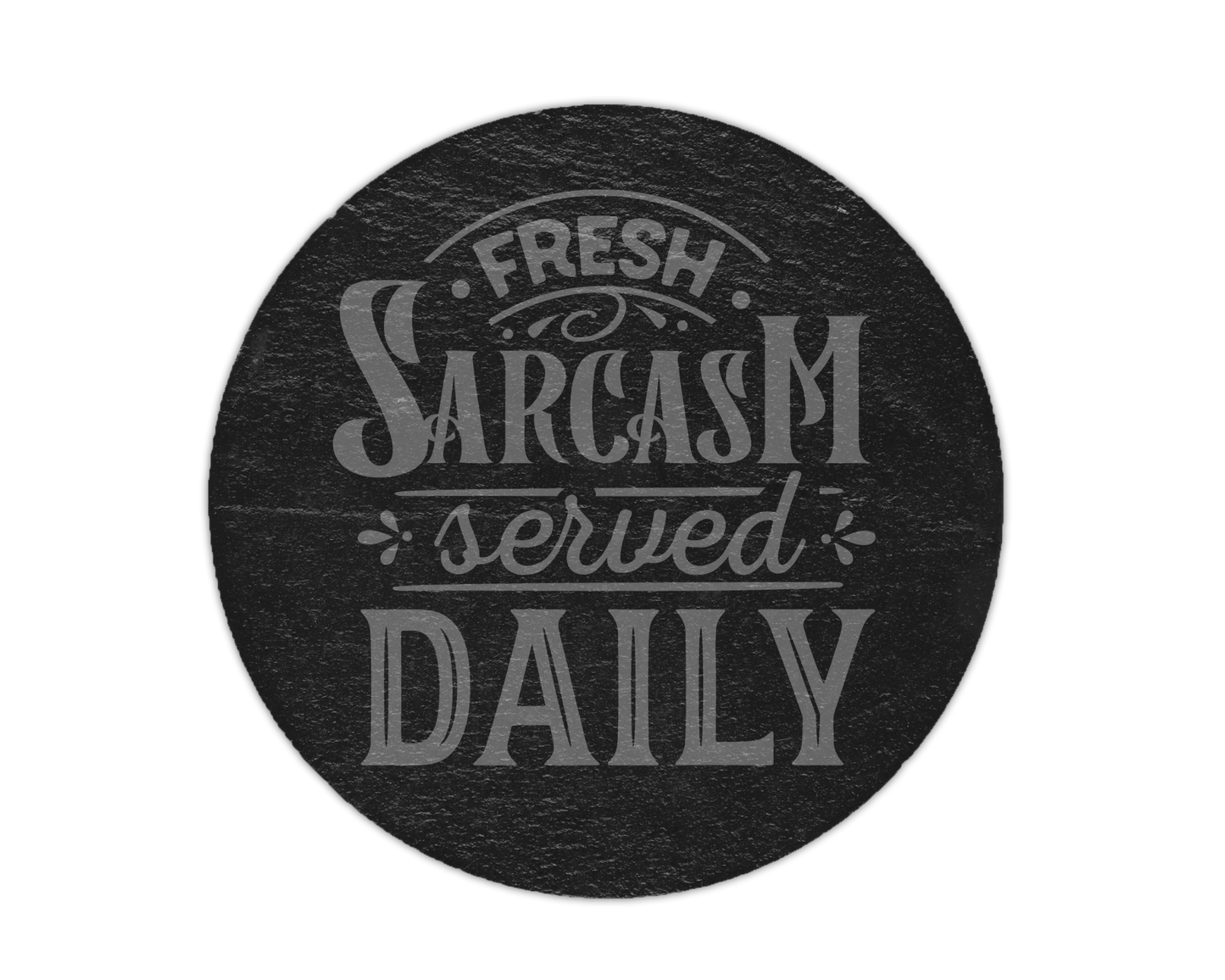 A round black slate coaster or plaque featuring the phrase 'Fresh Sarcasm served DAILY' in a light gray stylized font, shown against a plain white background.
