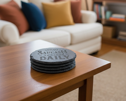 a stack of four slate coasters that say "Fresh Sarcasm Served Daily" sitting on a coffee table in a living room.