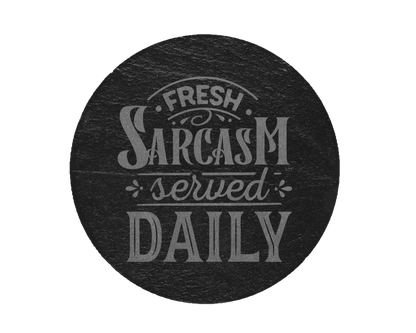 A laser engraved round slate coaster that says fresh sarcasm served daily